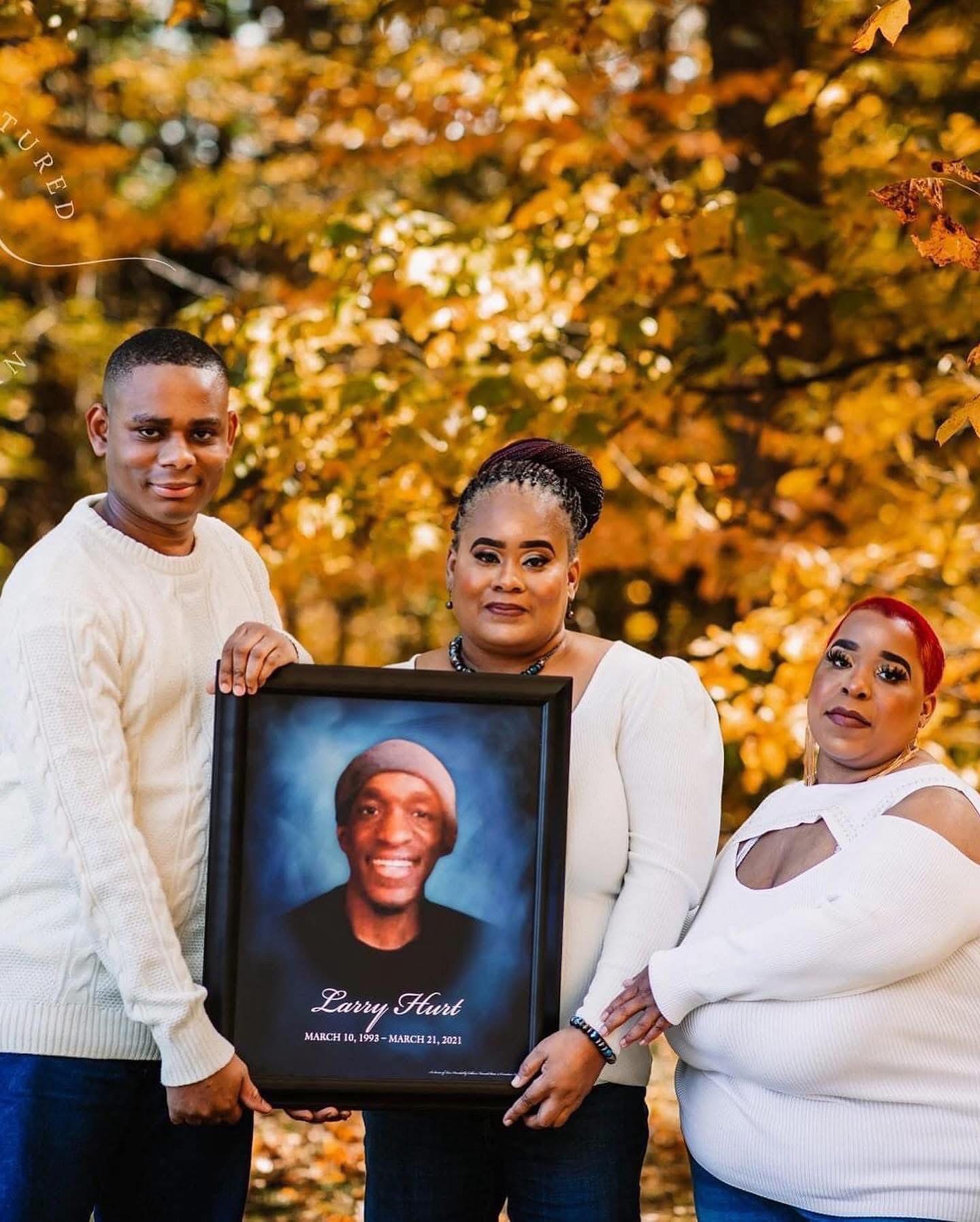 Family holding Larry Hurt's portrait